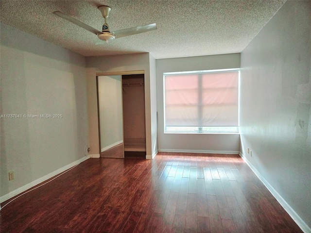 unfurnished bedroom with a textured ceiling, baseboards, and wood finished floors