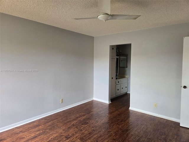 empty room featuring dark wood-style floors, ceiling fan, a textured ceiling, and baseboards