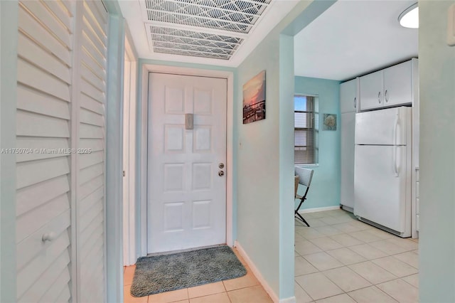 interior space with light tile patterned floors, visible vents, and baseboards