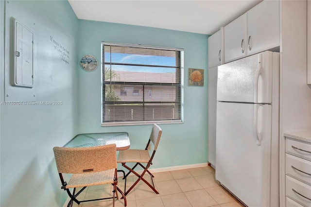 dining space featuring light tile patterned flooring and baseboards