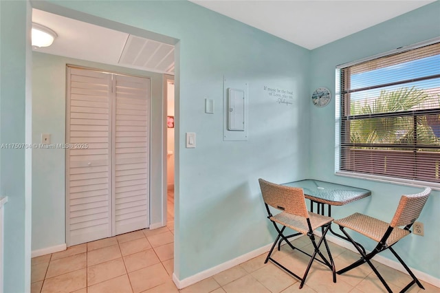 dining area featuring tile patterned flooring, electric panel, and baseboards