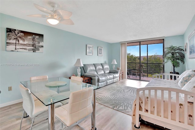 interior space with a textured ceiling, wood finished floors, baseboards, access to outside, and floor to ceiling windows