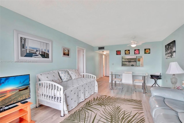 living room featuring ceiling fan, wood finished floors, visible vents, and baseboards