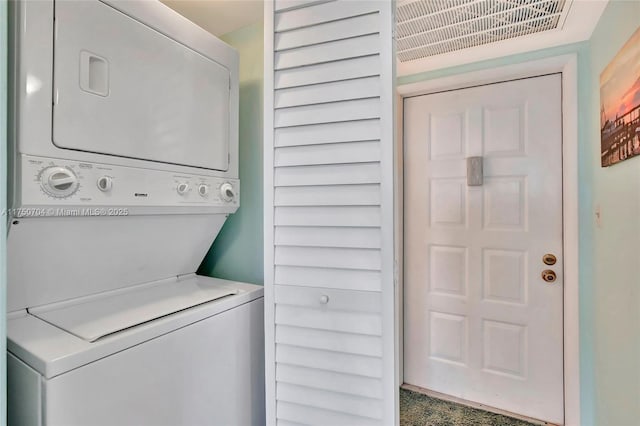 laundry room featuring laundry area and stacked washer / drying machine