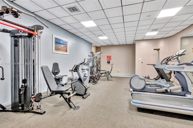 workout area featuring baseboards, visible vents, and a drop ceiling