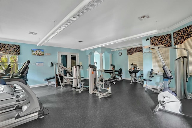 workout area featuring ornamental molding, visible vents, and baseboards