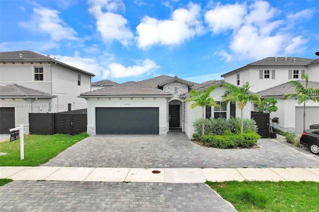 12735 SW 211th St, Miami, FL 33177 - view of front of property with an attached garage, decorative driveway, stucco siding, a tile roof, and a gate