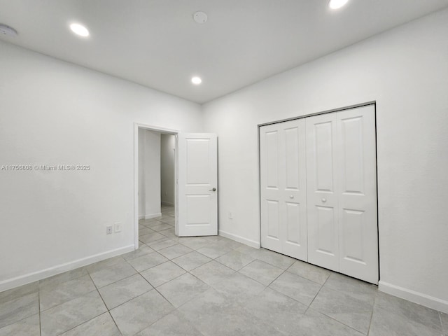 unfurnished bedroom featuring recessed lighting, a closet, baseboards, and light tile patterned floors