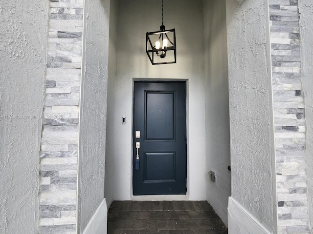 doorway to property featuring brick siding and stucco siding