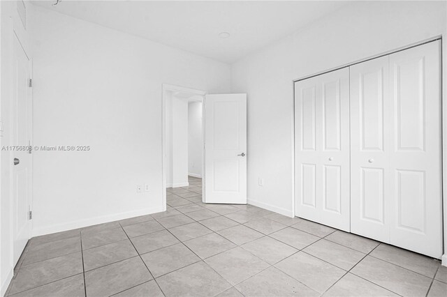 12735 SW 211th St, Miami, FL 33177 - unfurnished bedroom featuring light tile patterned floors, a closet, and baseboards