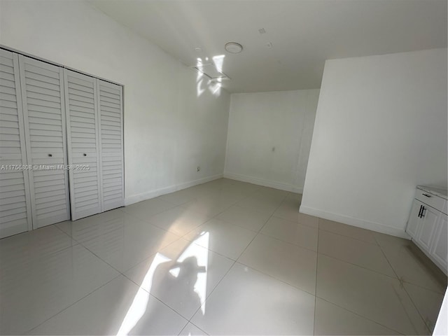 unfurnished bedroom featuring light tile patterned flooring and baseboards