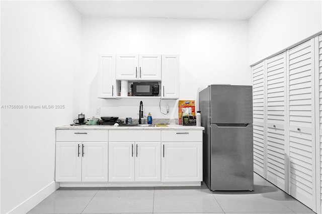 12735 SW 211th St, Miami, FL 33177 - kitchen with freestanding refrigerator, black microwave, a sink, white cabinets, and light countertops