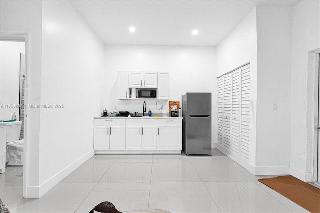 12735 SW 211th St, Miami, FL 33177 - kitchen with freestanding refrigerator, black microwave, baseboards, white cabinetry, and recessed lighting