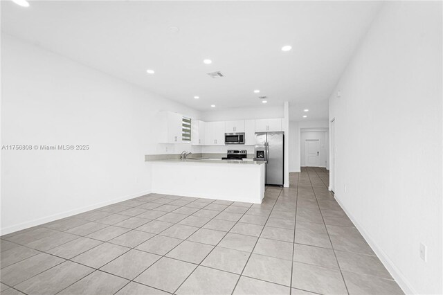 12735 SW 211th St, Miami, FL 33177 - kitchen featuring appliances with stainless steel finishes, a peninsula, recessed lighting, white cabinetry, and light countertops