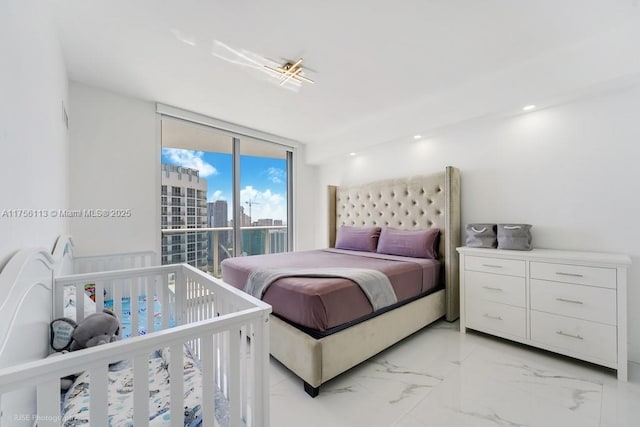 bedroom featuring a wall of windows, access to outside, marble finish floor, and a city view