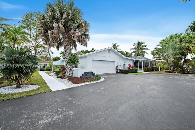 view of front facade featuring a garage, driveway, and a lanai