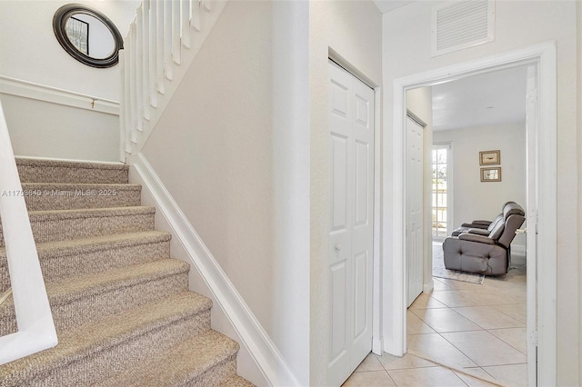 stairway featuring visible vents and tile patterned floors