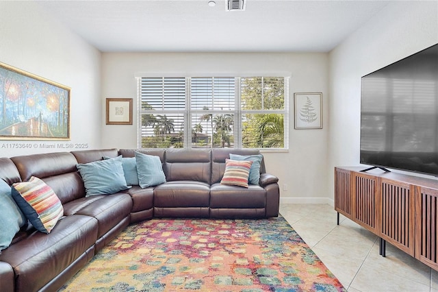 living room with light tile patterned flooring, visible vents, and baseboards