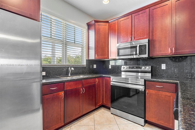 kitchen with stainless steel appliances, a sink, decorative backsplash, and dark brown cabinets