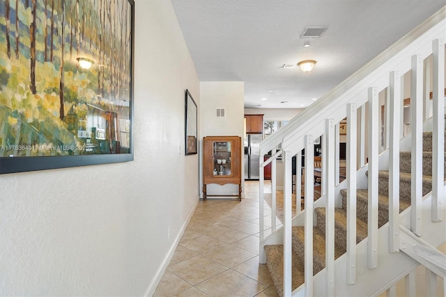 1835 N Dixie Hwy, Fort Lauderdale, FL 33305 - hall with stairs, light tile patterned floors, baseboards, visible vents, and a textured ceiling