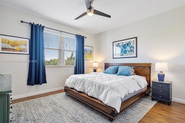 bedroom featuring a ceiling fan, baseboards, and wood finished floors