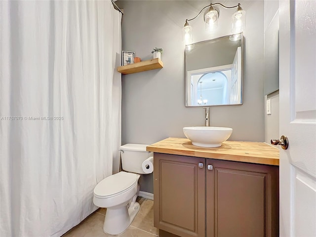 bathroom with toilet, curtained shower, tile patterned flooring, and vanity