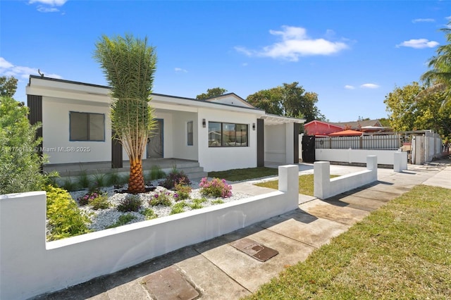 view of front of property featuring fence and stucco siding