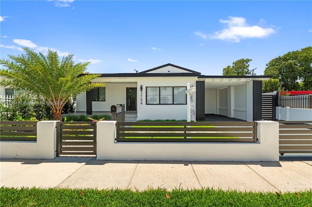 view of front of home with stucco siding, a fenced front yard, a gate, and covered porch