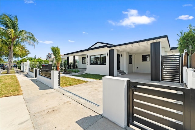 view of front of home with a gate, a fenced front yard, and stucco siding