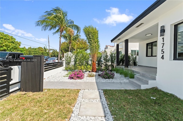 view of yard featuring covered porch and fence