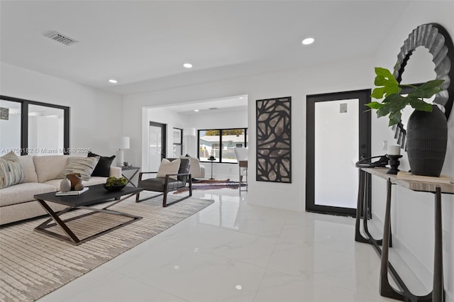 living area with recessed lighting, visible vents, and marble finish floor