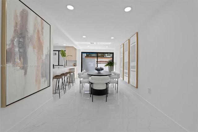 dining space featuring baseboards, recessed lighting, and marble finish floor