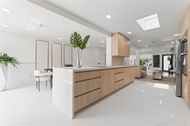 kitchen featuring recessed lighting, light brown cabinets, modern cabinets, and a skylight