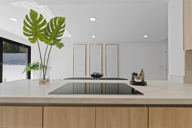 kitchen featuring light brown cabinetry, black electric cooktop, and recessed lighting
