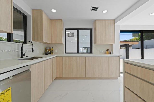 kitchen with a sink, light brown cabinetry, and modern cabinets