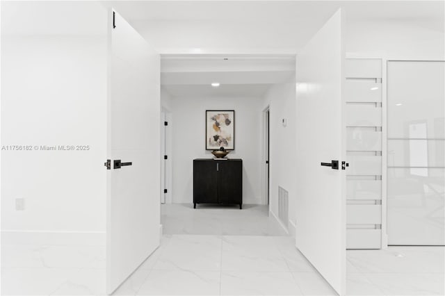 hallway with visible vents and marble finish floor