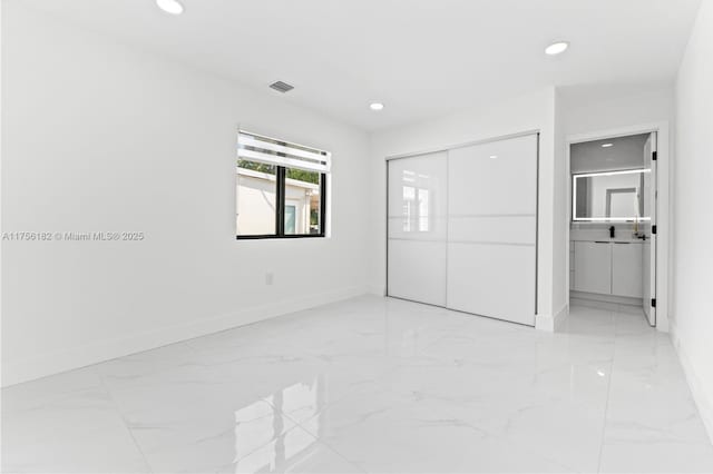 unfurnished bedroom with recessed lighting, marble finish floor, and baseboards