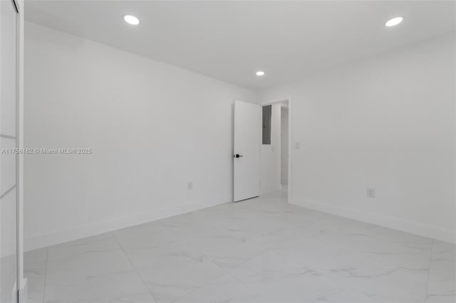unfurnished room featuring marble finish floor, baseboards, and recessed lighting