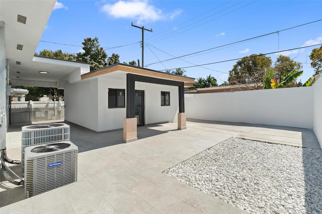 view of patio / terrace featuring an outbuilding, a fenced backyard, and cooling unit