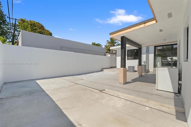 view of patio featuring central AC unit and fence
