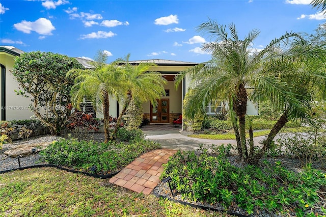 view of exterior entry with stucco siding, metal roof, and french doors