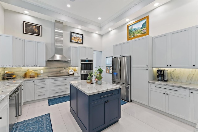 kitchen with stainless steel appliances, ornamental molding, wall chimney exhaust hood, and light tile patterned floors