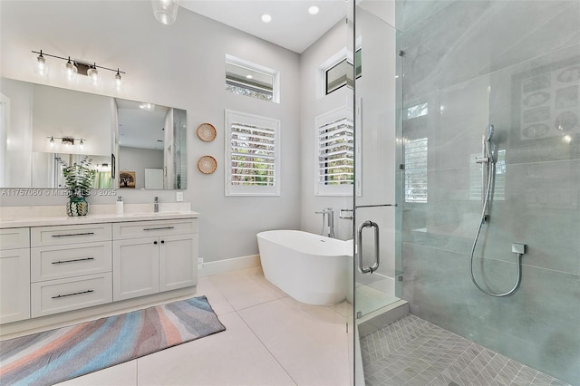 bathroom featuring baseboards, tiled shower, tile patterned flooring, vanity, and a freestanding tub