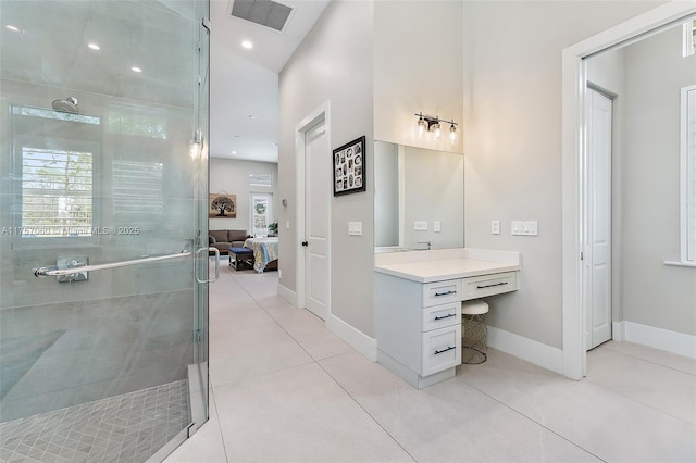 ensuite bathroom with visible vents, tile patterned floors, ensuite bathroom, vanity, and a shower stall