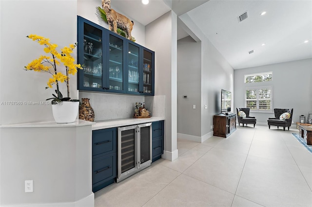 bar with a dry bar, baseboards, visible vents, decorative backsplash, and wine cooler