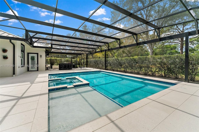 view of swimming pool with a patio area, a pool with connected hot tub, and glass enclosure