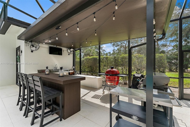 view of patio with outdoor wet bar and a lanai