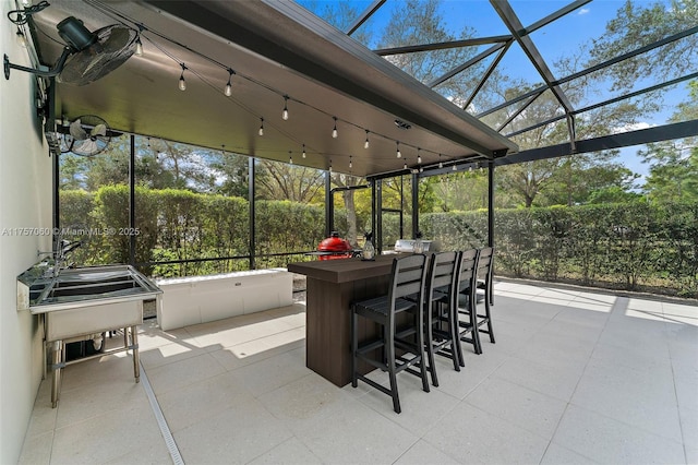 view of patio / terrace featuring glass enclosure and outdoor dry bar