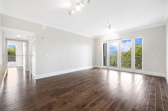 empty room with baseboards, ornamental molding, dark wood-type flooring, rail lighting, and french doors