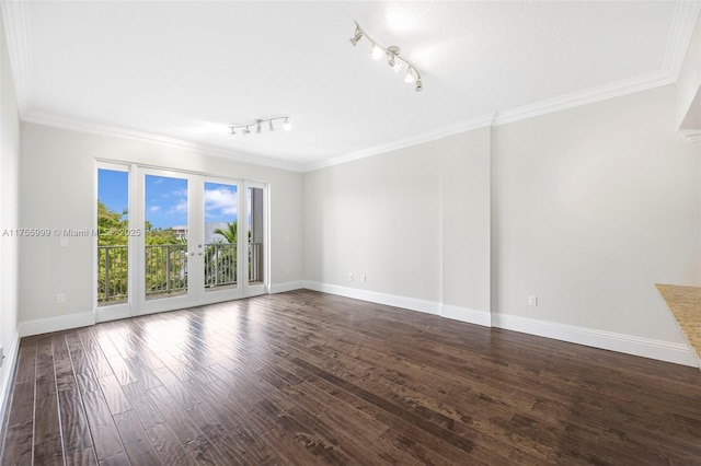 unfurnished room with dark wood-style floors, baseboards, ornamental molding, and french doors